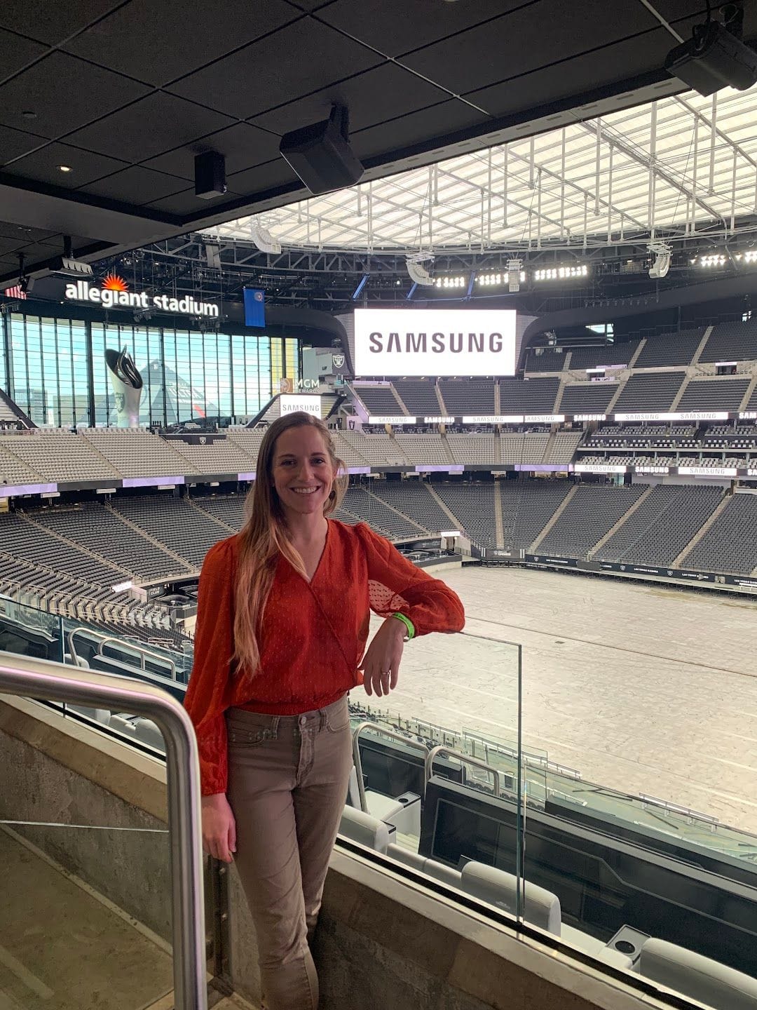 Carolyn at Allegiant Stadium, with the field and Samsung display behind her.